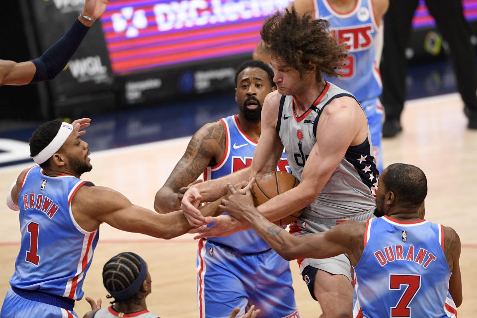 Brooklyn Nets guard Bruce Brown (1) and forward Kevin Durant (7) battle for the ball against Washington Wizards center Robin Lopez, second from right, during the first half of an NBA basketball game, Sunday, Jan. 31, 2021, in Washington. (AP Photo/Nick Wass)