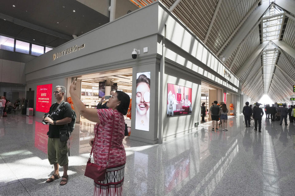 A tourist takes a selfie in the Siem Reap-Angkor International Airport, in Cambodia as it opened Thursday, Nov. 16, 2023. Cambodia on Thursday officially inaugurated the country's newest and biggest airport, a Chinese-financed project meant to serve as an upgraded gateway to the country’s major tourist attraction, the centuries-old Angkor Wat temple complex in the northwestern province of Siem Reap. (AP Photo/Heng Sinith)