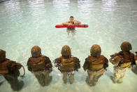 PARRIS ISLAND, SC - FEBRUARY 25: Sgt. Gustavo Ramos of Pomona, California teaches female Marine recruits to remove body armor while under water during boot camp February 25, 2013 at MCRD Parris Island, South Carolina. Male and female recruits are expected to meet the same standards during their swim qualification test. All female enlisted Marines and male Marines who were living east of the Mississippi River when they were recruited attend boot camp at Parris Island. About six percent of enlisted Marines are female. (Photo by Scott Olson/Getty Images)