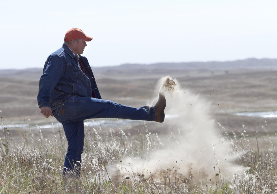 FILE - In this Sept. 29, 2011 file photo Atkinson, Neb., rancher Bruce Boettcher, who opposes the Keystone XL pipeline, kicks up sand on his land, to demonstrate the fragility of the sand hills near the planned route of the pipeline. The long-delayed Keystone XL oil pipeline cleared a major hurdle Friday, Jan. 31, 2014 as the U.S.State Department raised no major environmental objections to the controversial pipeline from Canada through the heart of the U.S. Republicans and some oil- and gas-producing states cheered, but the report further rankled environmentalists already at odds with President Barack Obama. (AP Photo/Nati Harnik, File)