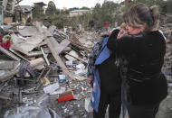 A neighbour comforts home owner, Lida Sarksyan, left, near her house destroyed by shelling from Azerbaijan's artillery during a military conflict in Stepanakert, the separatist region of Nagorno-Karabakh, Saturday, Oct. 17, 2020. The latest outburst of fighting between Azerbaijani and Armenian forces began Sept. 27 and marked the biggest escalation of the decades-old conflict over Nagorno-Karabakh. The region lies in Azerbaijan but has been under control of ethnic Armenian forces backed by Armenia since the end of a separatist war in 1994. (AP Photo)