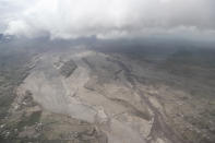 The swaths of ash from the eruption of Mount Semeru covers a village area in Lumajang district, East Java province, Indonesia, Monday, Dec. 6, 2021. The highest volcano on Java island spewed thick columns of ash into the sky in a sudden eruption Saturday triggered by heavy rains. Villages and nearby towns were blanketed and several hamlets buried under tons of mud from volcanic debris. (AP Photo/Trisnadi)