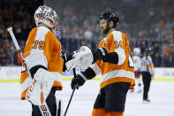 Philadelphia Flyers' Sean Couturier (14) celebrates with Carter Hart (79) after a goal by Couturier during the first period of an NHL hockey game against the Columbus Blue Jackets, Tuesday, Feb. 18, 2020, in Philadelphia. (AP Photo/Matt Slocum)