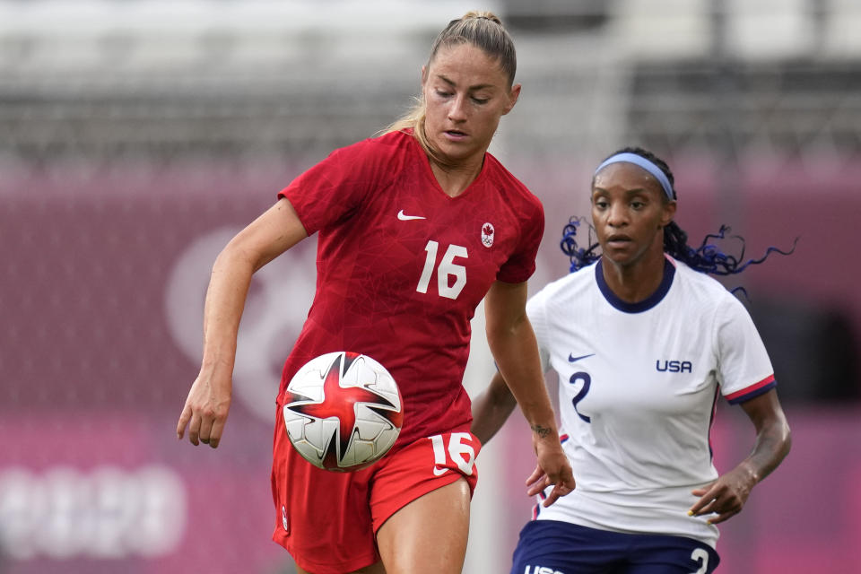 Canada's Janine Beckie, left, and United States' Crystal Dunn battle for the ball during a women's semifinal soccer match at the 2020 Summer Olympics, Monday, Aug. 2, 2021, in Kashima, Japan. (AP Photo/Andre Penner)