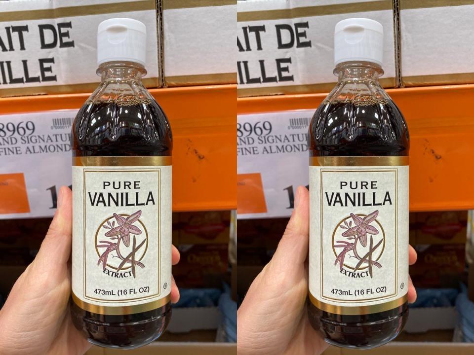 A hand holding a bottle of vanilla extract in costco