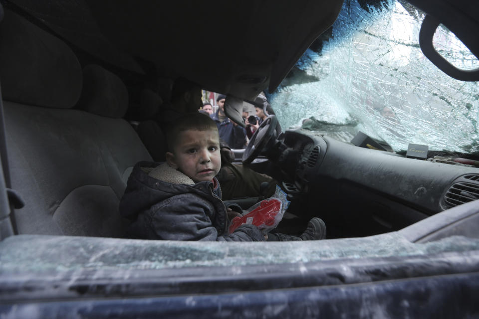 A boy cries in a damaged car after government airstrikes in the town of Ariha, in Idlib province, Syria, Wednesday, Jan. 15, 2020. Syrian government warplanes struck a market and an industrial area Wednesday in the last territory in the hands of rebel groups in the country's northwest, killing at least 15 people, opposition activists said. (AP Photo/Ghaith Alsayed)