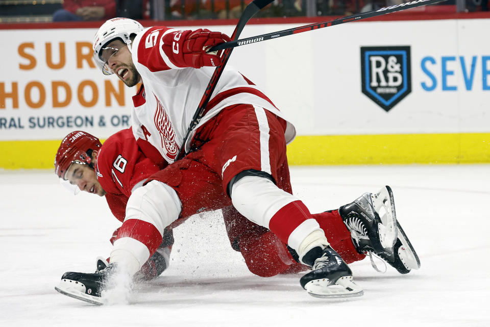Detroit Red Wings' David Perron (57) tangles with Carolina Hurricanes' Brady Skjei (76) during the first period of an NHL hockey game in Raleigh, N.C., Tuesday, April 11, 2023. (AP Photo/Karl B DeBlaker)