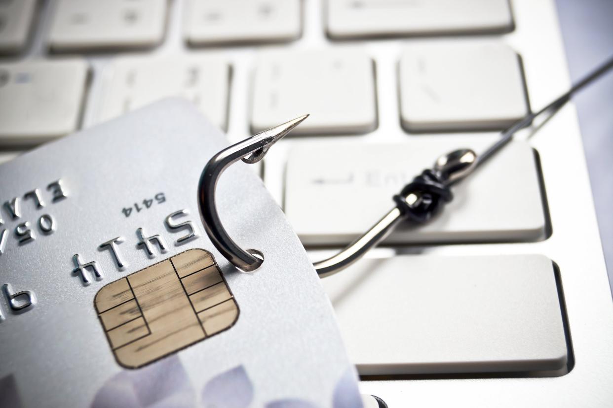 fish hook with a credit card on white computer keyboard