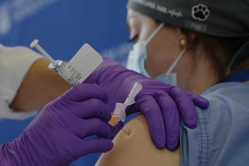 Catalina Gonzalez-Marques, an emergency medical physician, receives the Pfizer-BioNTech coronavirus vaccine at Brigham and Women's Hospital, Wednesday, Dec. 16, 2020, in Boston. (Brian Snyder/Pool via AP)