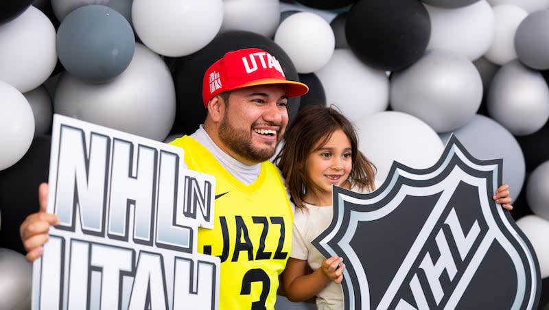 EJ and Ellie Ayala hold NHL signs in a photo booth at an event held to celebrate Utah’s new NHL team at the Delta Center in Salt Lake City on Wednesday, April 24, 2024.