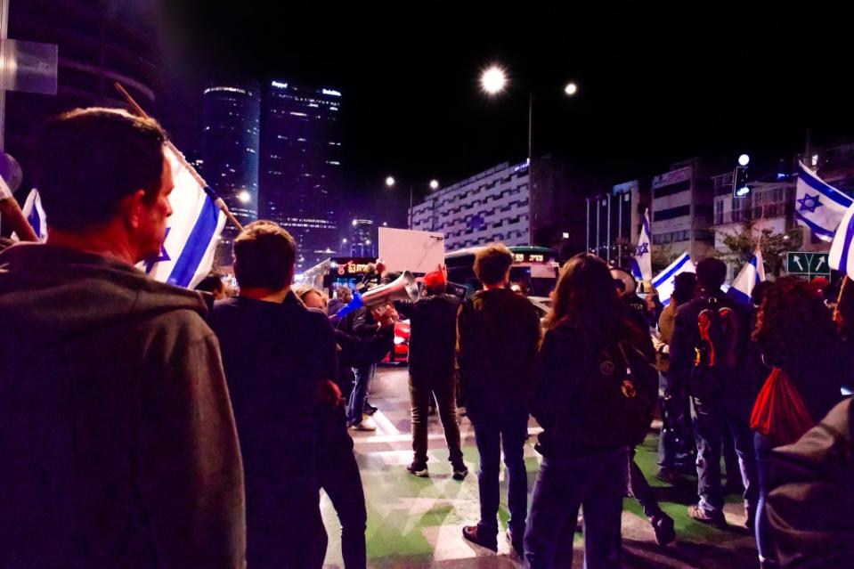 Anti-government protesters block traffic in Tel Aviv on Saturday night, calling for the safe release of hostages and the resignation of Israeli Prime Minister Benjamin Netanyahu. (Photo by Charlotte Lawson)