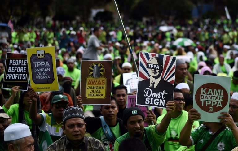 Malaysian activists hold placards denouncing the US-led Trans-Pacific Partnership agreement (TPP) during a protest in Kuala Lumpur