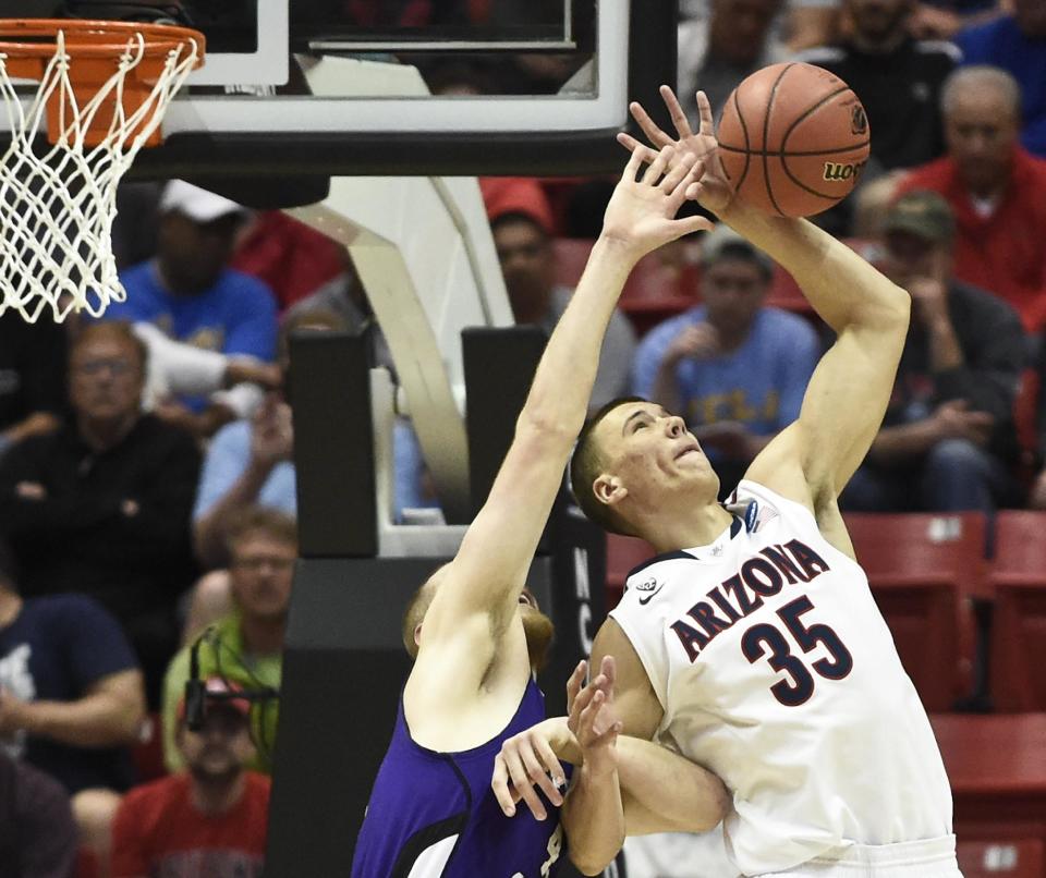 Arizona center Kaleb Tarczewski battles with Weber State center Kyle Tresnak for a rebound during the first half in a second-round game in the NCAA college basketball tournament Friday, March 21, 2014, in San Diego. (AP Photo/Denis Poroy)