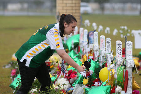 Santa Fe High School student Sierra Dean mourns the death of her friends killed in a recent shooting at a makeshift memorial left in their memory at Santa Fe High School in Santa Fe, Texas, U.S., May 23, 2018. REUTERS/Loren Elliott