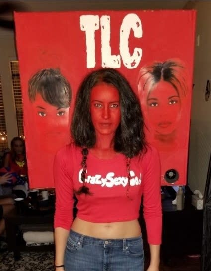 Someone dressed in red with their face cut into the backdrop of the "CrazySexyCool" album