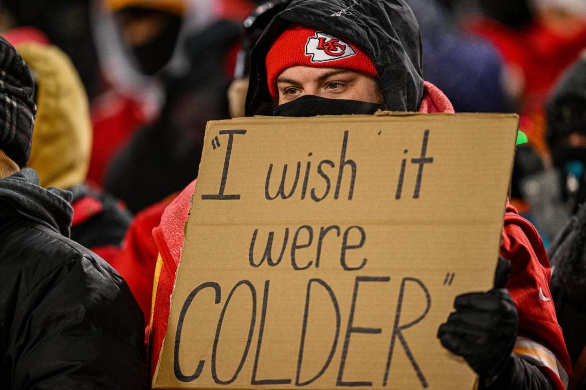 A Kansas City Chiefs fan holds a sign about the cold weather Saturday, Jan. 13, 2024, at GEHA Field at Arrowhead Stadium.