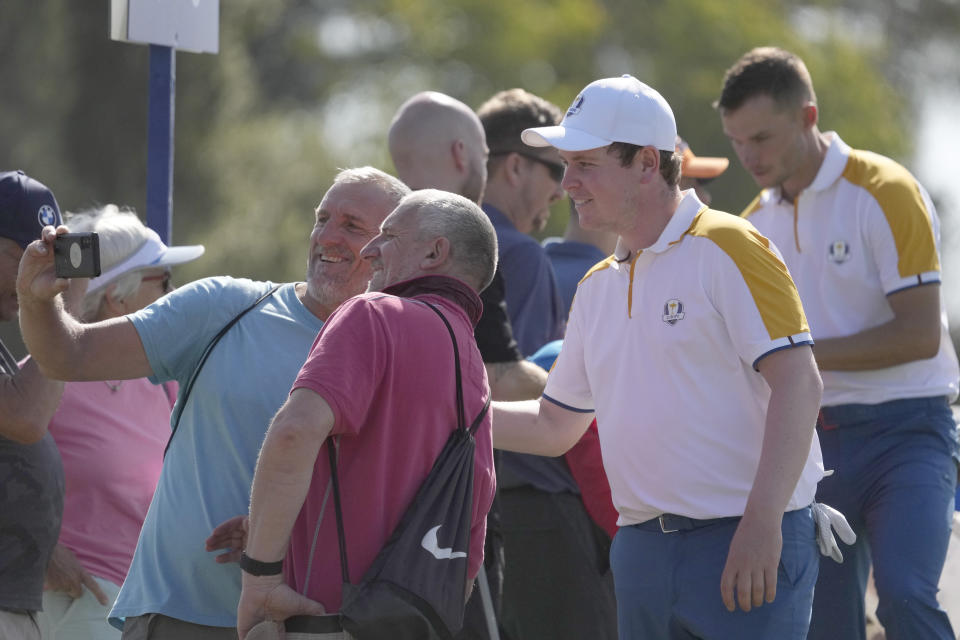 Europe's Robert Macintyre poses for photo with fans during a practice round ahead of the Ryder Cup at the Marco Simone Golf Club in Guidonia Montecelio, Italy, Tuesday, Sept. 26, 2023. The Ryder Cup starts Sept. 29, at the Marco Simone Golf Club. (AP Photo/Andrew Medichini)