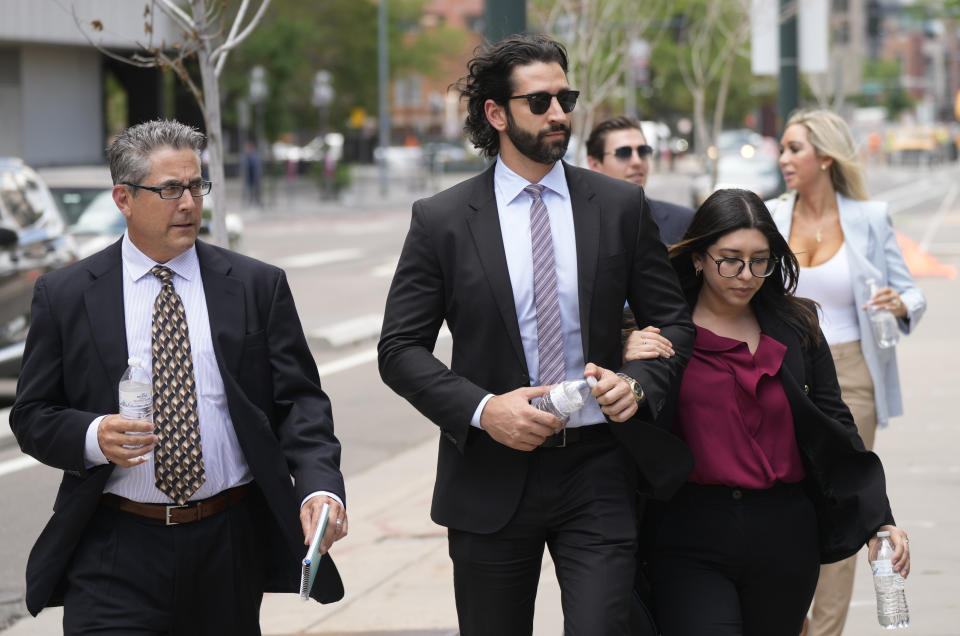 Defense attorneys for Pittsburgh dentist Lawrence "Larry" Rudolph head into federal courthouse with the dentist's children for the afternoon session of the trial, Wednesday, July 13, 2022, in Denver. (AP Photo/David Zalubowski)
