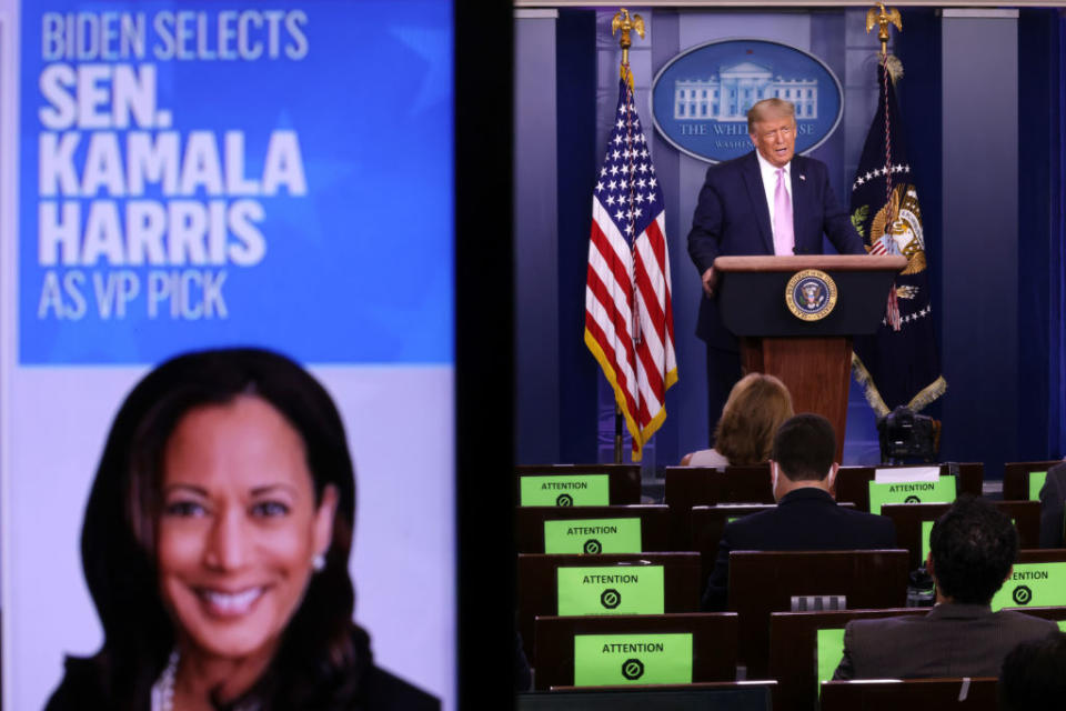 President Donald Trump speaks as a picture of Kamala Harris is seen on a screen during a news conference this morning. Source: Getty