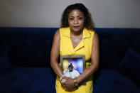 Daphne Bolton poses for a portrait holding a photograph of her brother at her home on Monday, May 31, 2021, in Charlotte, N.C. Bolton's brother, Johnny Lorenzo Bolton, a 49-year-old Black man was shot to death by a Cobb County Sheriff's Office SWAT team member serving a search warrant last December. (AP Photo/Chris Carlson)