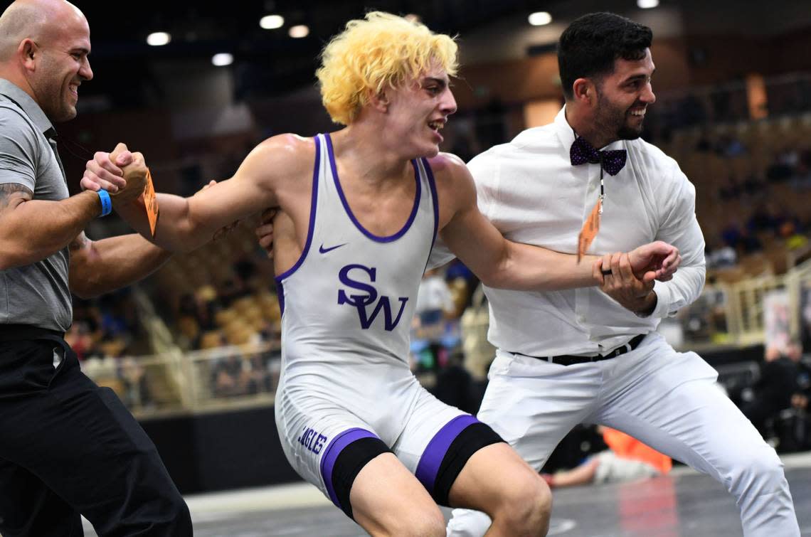 Southwest Miami’s Adrian Ochoa celebrates with the coaching staff after winning the 160-pound state title match on Saturday at Silver Spurs Arena in Kissimmee.