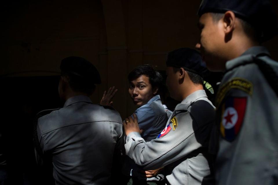 Reuters journalist Kyaw Soe Oo is escorted by police after a court appearance in Yangon, Myanmar on Jan. 10, 2018.