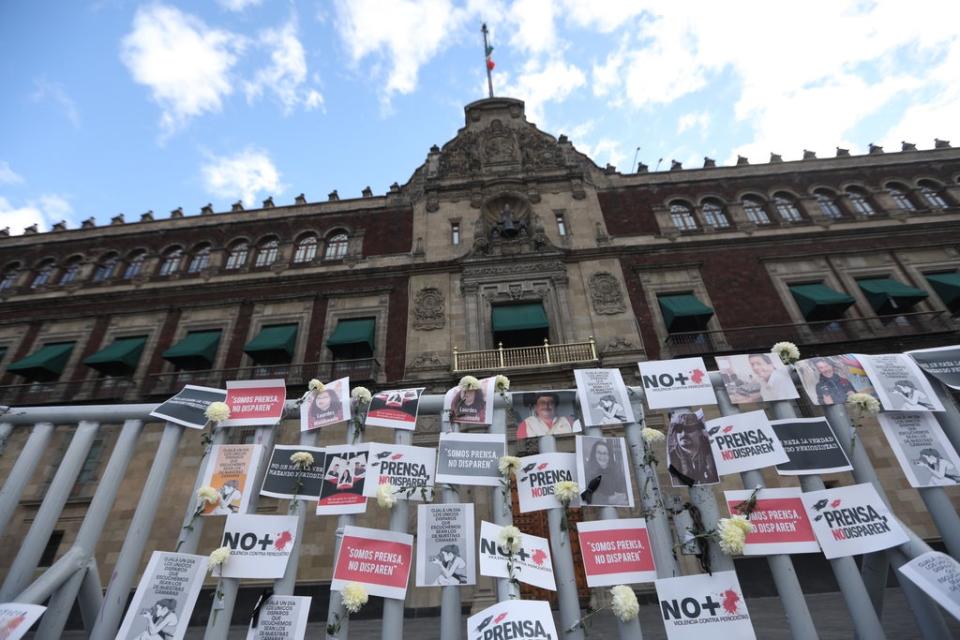 Posters, flowers, portraits and cameras outside the National Palace of Mexico City, (EPA)