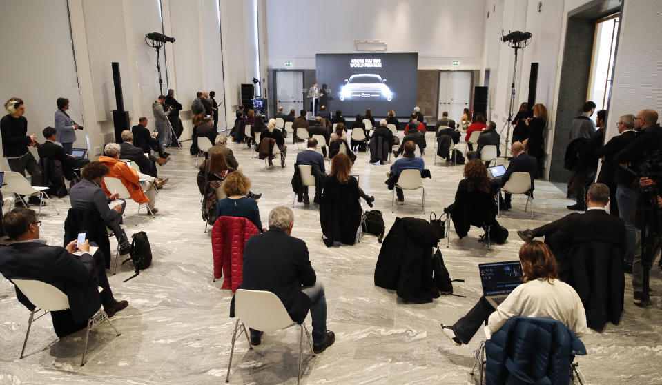 People sit a recommended distance apart from each other during the presentation of the new FIAT 500 electric n Milan, Italy, Wednesday, March 4, 2020. Countries are taking drastic and increasingly visible measures to curb the new coronavirus that first emerged in China and was spreading quickly through Europe, the Mideast and the Americas. (AP Photo/Antonio Calanni)