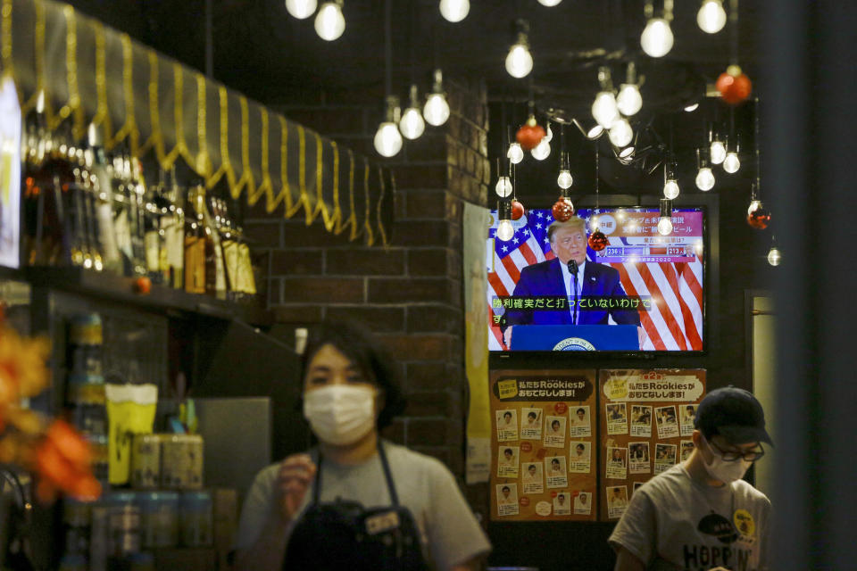 President Donald Trump speaking from the White House is projected on a television at a restaurant Wednesday, Nov. 4, 2020 in Tokyo. (AP Photo/Kiichiro Sato)