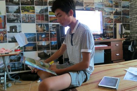 Lin Liyi, grandson of arrested village chief Lin Zuluan, who was detained and interrogated by Chinese authorities for twelve hours soon after his grandfather was arrested, looks at a land blueprint in his room in Wukan village in the southern province of Guangdong, China June 23, 2016. Picture taken June 23, 2016. REUTERS/James Pomfret