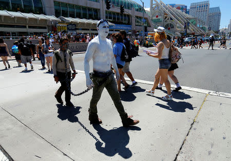 Two men in costume make their way across the street info of the convention center holding the pop culture event Comic-Con International in San Diego, California, United States, July 22, 2016. REUTERS/Mike Blake