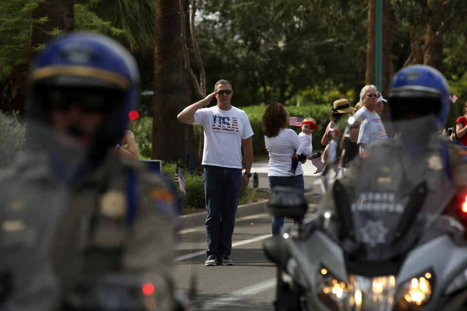 <p>A man salutes as a hearse carrying the casket of Sen. John McCain is escorted by Arizona State Troopers to a memorial service at the North Phoenix Baptist Church on Aug. 30, 2018 in Phoenix, Ariz. (Photo: Justin Sullivan/Getty Images) </p>
