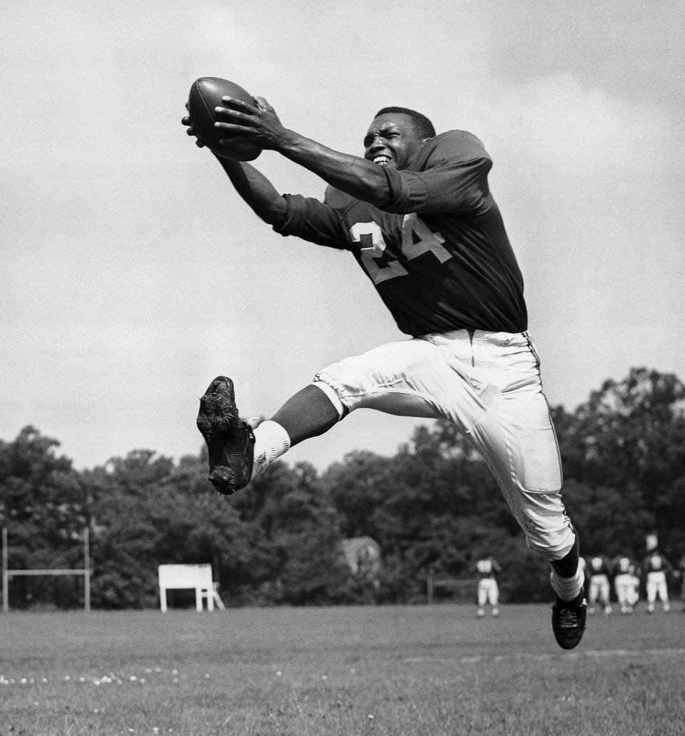 FILE - In this July 30, 1953, file photo, veteran halfback Wally Triplett of Penn State U., originally from La Mott, Pa., poses in action during his second year with Chicago Cardinals and fourth year in the National Football League. Triplett, who left his indelible mark on NFL history by becoming the first African-American player to be drafted and play for an NFL team, passed away Thursday, Nov. 8, 2018, the Detroit Lions announced. He was 92. (AP Photo/File)