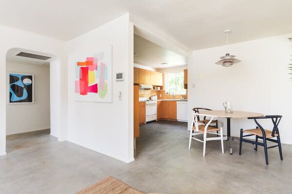 Polished concrete floors run throughout the open layout, connecting the main living areas.