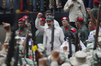 FILE - In this April 13, 2019 file photo, Venezuela's President Nicolas Maduro gestures to members of the Bolivarian Militia during their 10th anniversary celebration in Caracas, Venezuela. Last April, as a military uprising roiled Venezuela, Maduro’s socialist government ordered pay TV providers to immediately cease transmission of CNN and the BBC. DirecTV, which is wholly owned by AT&T, quickly obliged, yanking the two networks off the air. (AP Photo/Ariana Cubillos, File)