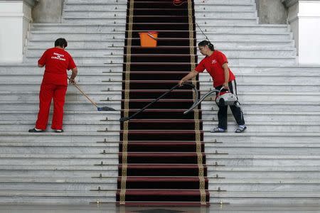 Workers clean a court in Bucharest September 24, 2014. REUTERS/Bogdan Cristel