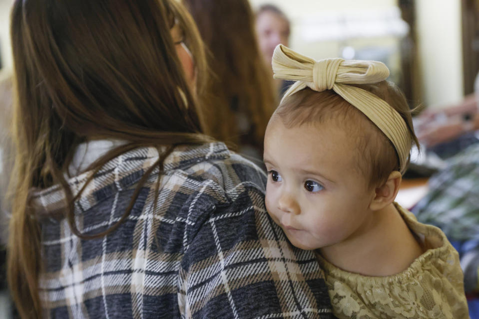 One-year-old Cora Dibert is held by her mother, Morgan Shurtleff, at The Bridge Church, Saturday, Dec. 2, 2023, in Mustang, Okla. Kids suffering from lead poisoning should eat a diet high in vitamin D, calcium and iron and be given a stimulating environment that encourages brain development, according to Dr. Jennifer Sample, a pediatric toxicologist who consults for industry and academics. (AP Photo/Nate Billings)