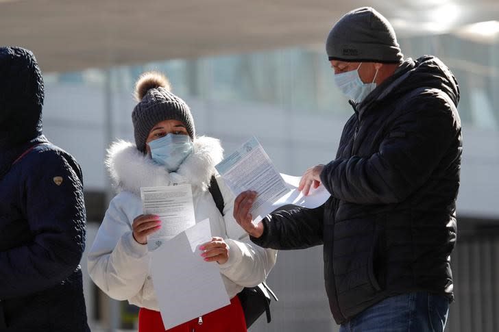 People gather outside a mobile laboratory for coronavirus disease testing near an airport in Saint Petersburg