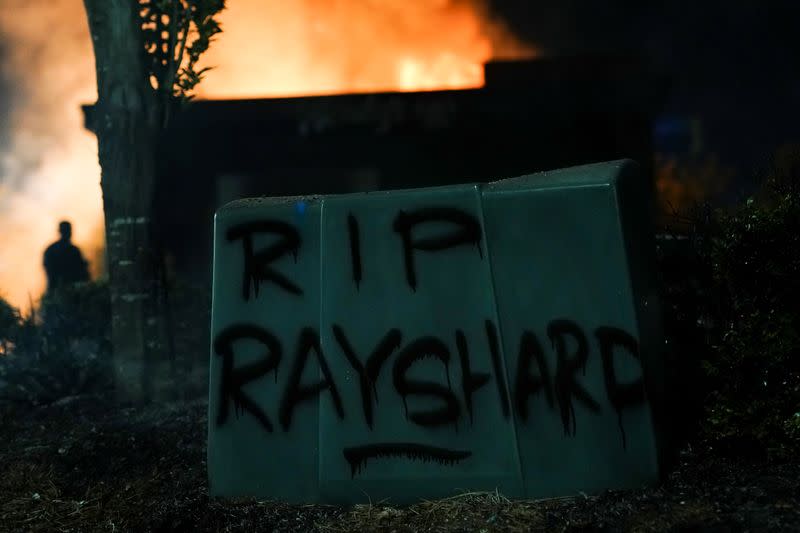 'RIP Rayshard' is seen written in spray paint as a Wendy’s burns following a rally against racial inequality and the police shooting death of Rayshard Brooks, in Atlanta