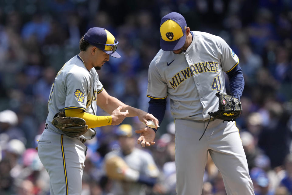 Milwaukee Brewers' Willy Adames hands starting pitcher Joe Ross the rosin bag to start the first inning of a baseball game against the Chicago Cubs Friday, May 3, 2024, in Chicago. (AP Photo/Charles Rex Arbogast)