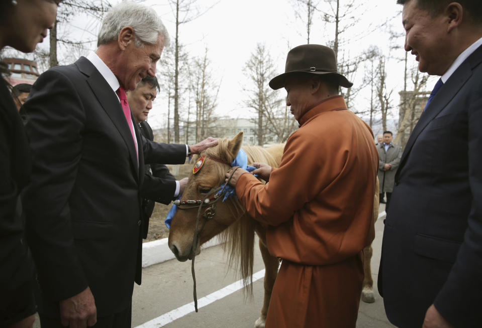 U.S. Secretary of Defense Chuck Hagel, left, is presented with a horse as a gift by Mongolian Defense Minister Bat-Erdene Dashdemberel, right, at the Mongolian Ministry of Defense, Thursday, April 10, 2014, in Ulan Bator, Mongolia. (AP Photo/Alex Wong, Pool)