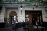 A statue with a broken arm, of Horacio Ferrer, an Uruguayan-Argentine poet stands outside Cafe Tortoni amid the new coronavirus pandemic in Buenos Aires, Argentina, Tuesday, Nov. 10, 2020. “This year has been very hard ... Before the cafe was always full, you had to wait to get in,” said Nicolas Prado, one of the managers of Cafe Tortoni, located in the center the Argentine capital, which is known for its European flair. (AP Photo/Natacha Pisarenko)