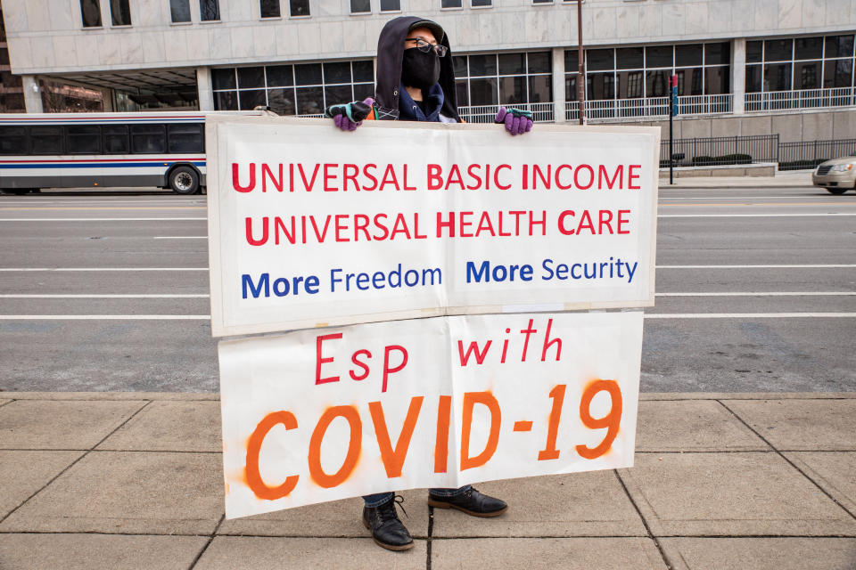 Individual demonstrator holds sign asking for Universal Basic Income and Universal Healthcare for all. (Stephen Zenner/SOPA Images/LightRocket via Getty Images)