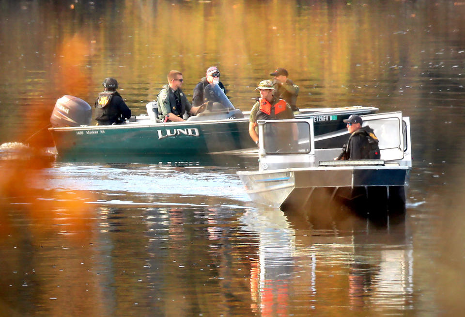 Police and ATF agents in boats search near the boat launch in the Androscoggin River where shooting suspect Robert Card abandoned his car, Oct. 27, 2023. / Credit: John Tlumacki/Globe Staff via Getty Images