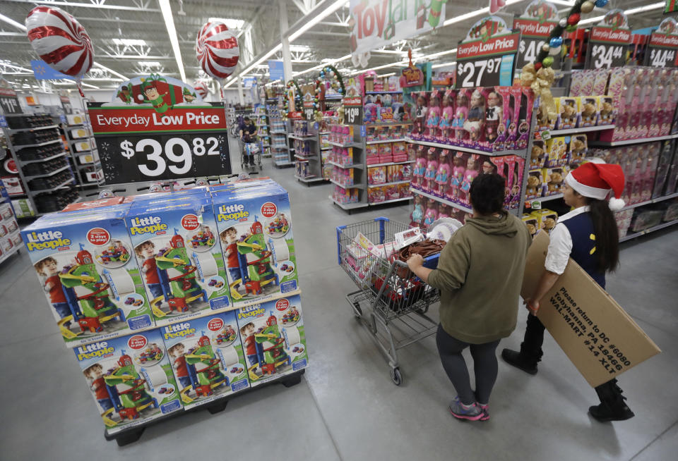 In this Wednesday, Oct. 26, 2016, file photo, a shopper, left, walks with a store associate in the toy section at Walmart in Teterboro, N.J. (AP Photo/Julio Cortez, File)