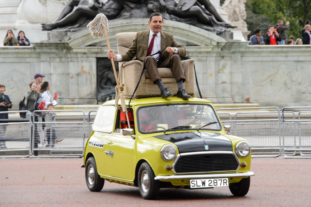 British actor Rowan Atkinson, dressed as Mr. Bean, sits on top of a Mini Cooper to promote the 25th anniversary of 