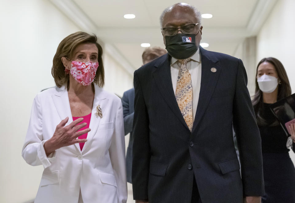 Speaker of the House Nancy Pelosi, D-Calif., walks with House Majority Whip James Clyburn, D-S.C., right, to meet with reporters after the House approved the Democrats' social and environment bill, giving a victory to President Joe Biden, at the Capitol in Washington, Friday, Nov. 19, 2021. (AP Photo/J. Scott Applewhite)