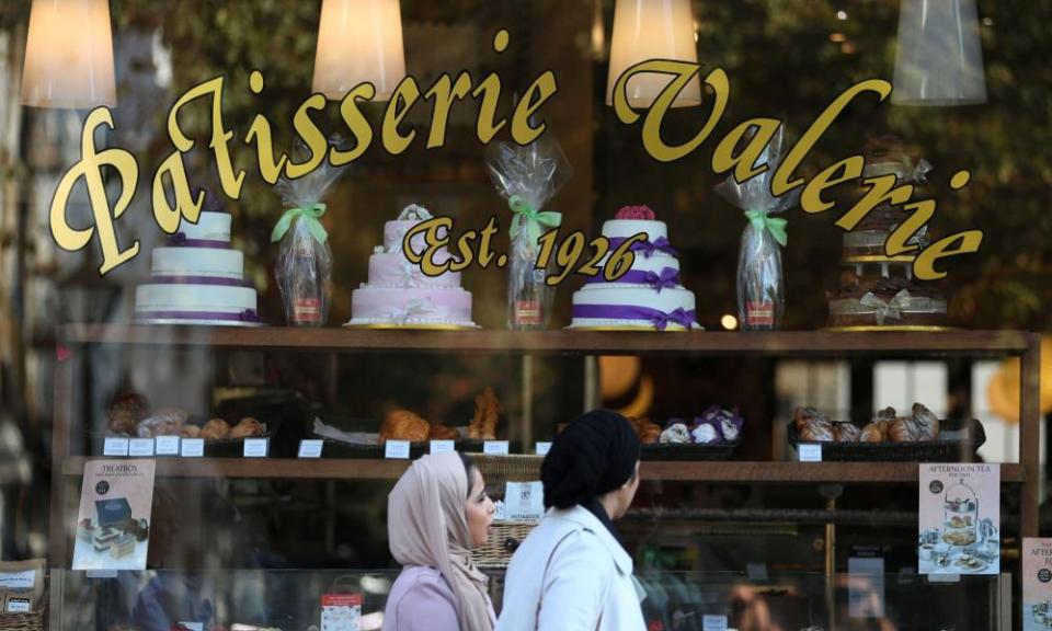 Women walk past a branch of Patisserie Valerie in London.