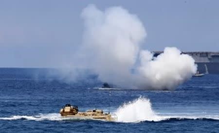 U.S. military forces aboard Amphibious Assault Vehicles (AAV) manuevre on South China Sea near the shore of San Antonio, Zambales during the annual "Balikatan" (shoulder-to-shoulder) war games with Filipino soldiers in northern Philippines April 21, 2015. REUTERS/Erik De Castro