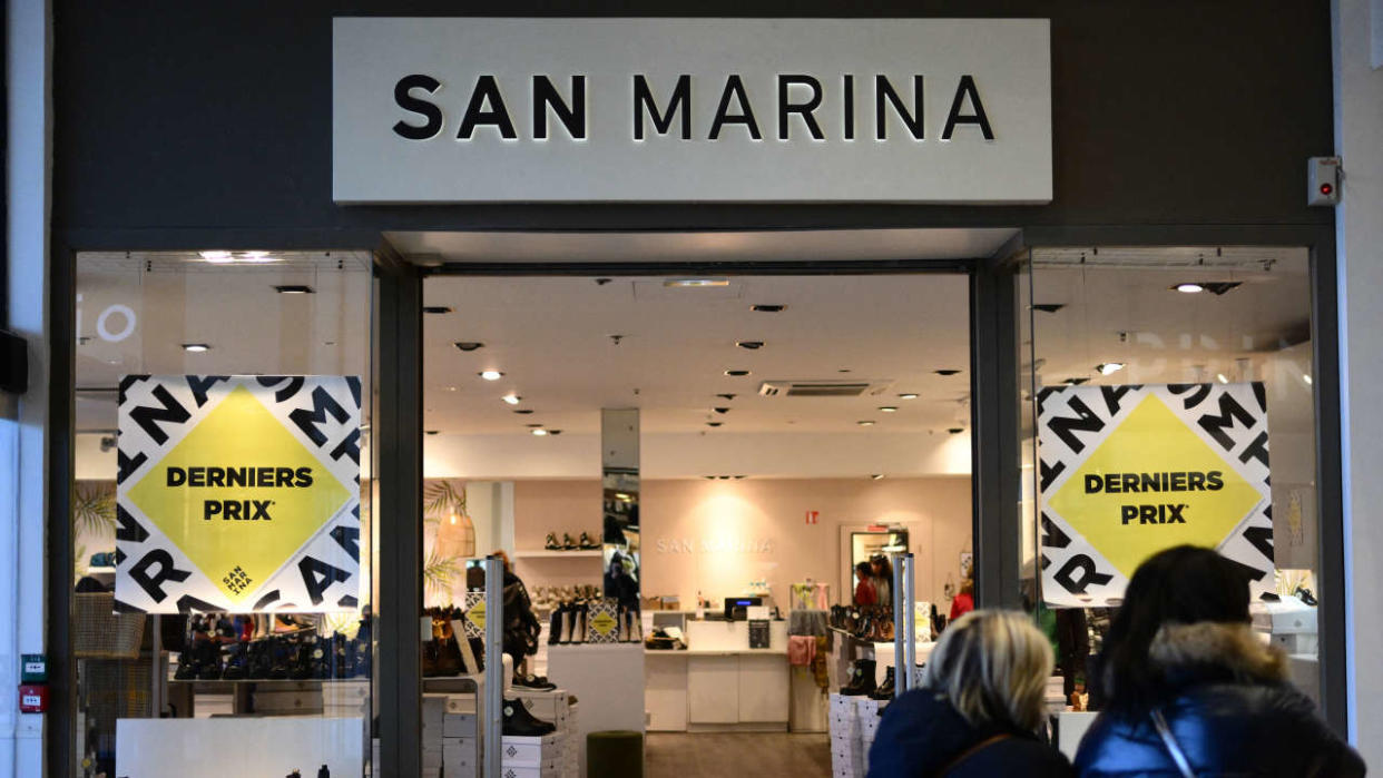 People walk along a San Marino shoe shop, in Marseille, southern France, on February 14, 2023. - The decision on the future of San Marina, a shoe company under judicial revew that employs more than 600 people in France, will be made on February 20, the company said on February 10, 2023. (Photo by Christophe SIMON / AFP)